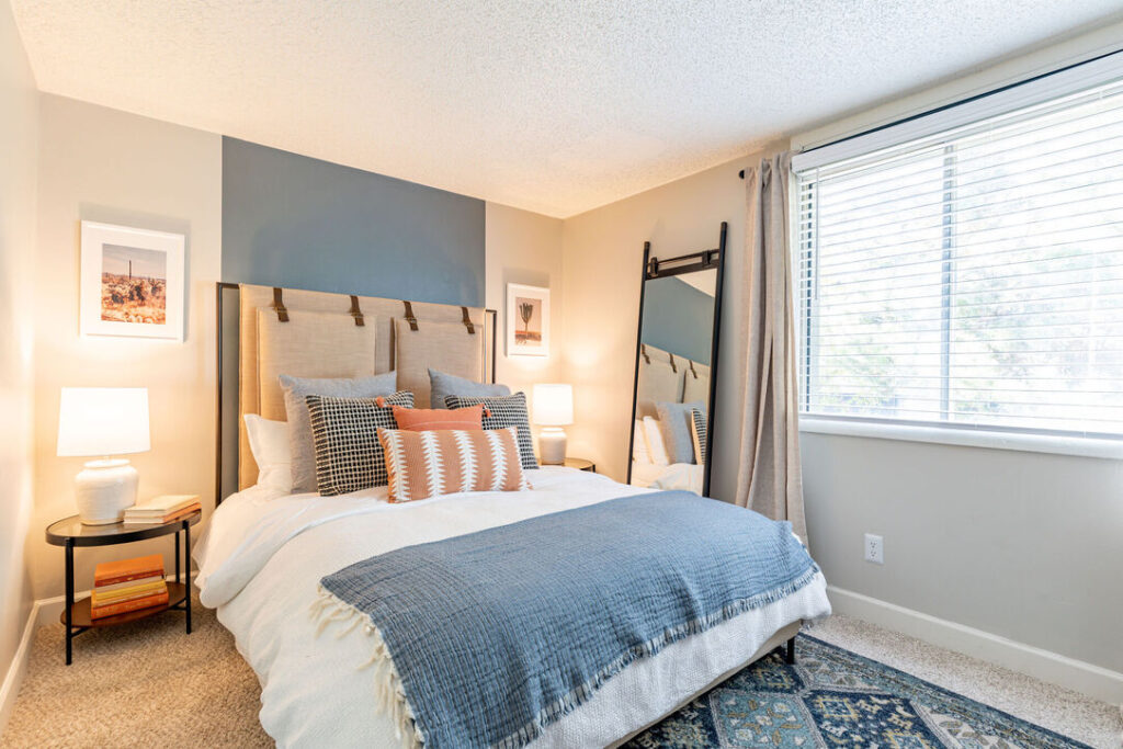 Bedroom with large window and blue accent wall