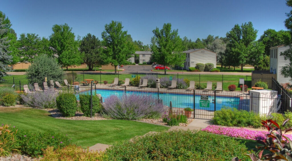 fenced pool area with lush landscaping