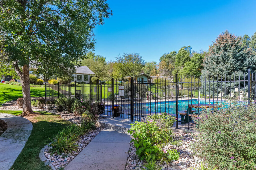 fenced pool area with lush landscaping
