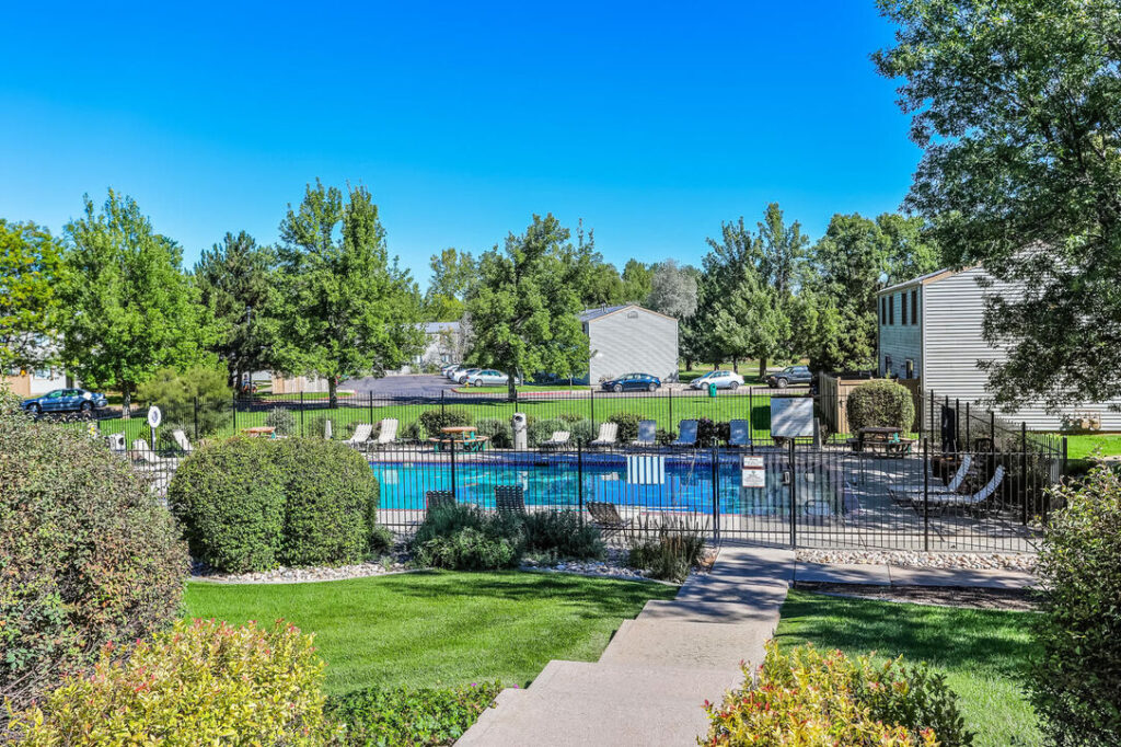 fenced pool area with lush landscaping