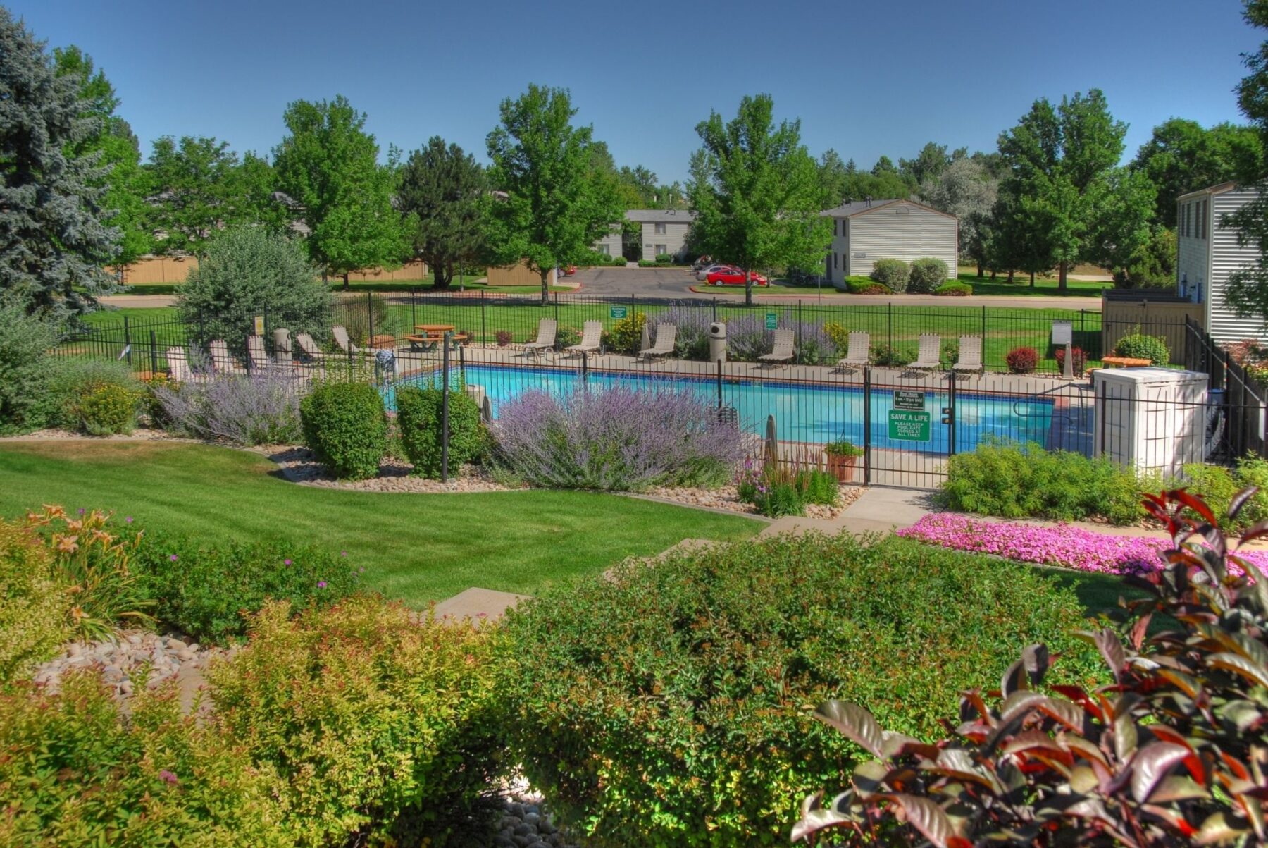 fenced swimming pool with deck seating and tables