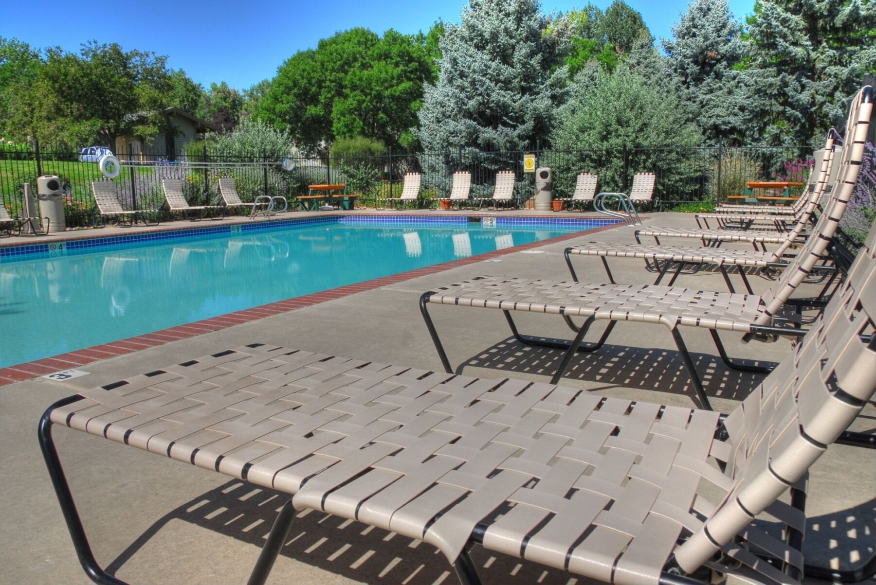 Swimming pool with deck furniture at The Hewing luxury apartments in Fort Collins