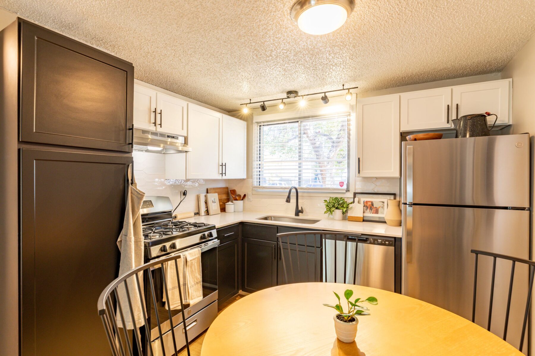 Kitchen with white counters and stainless steel appliances at The Hewing apartments for rent in Fort Collins