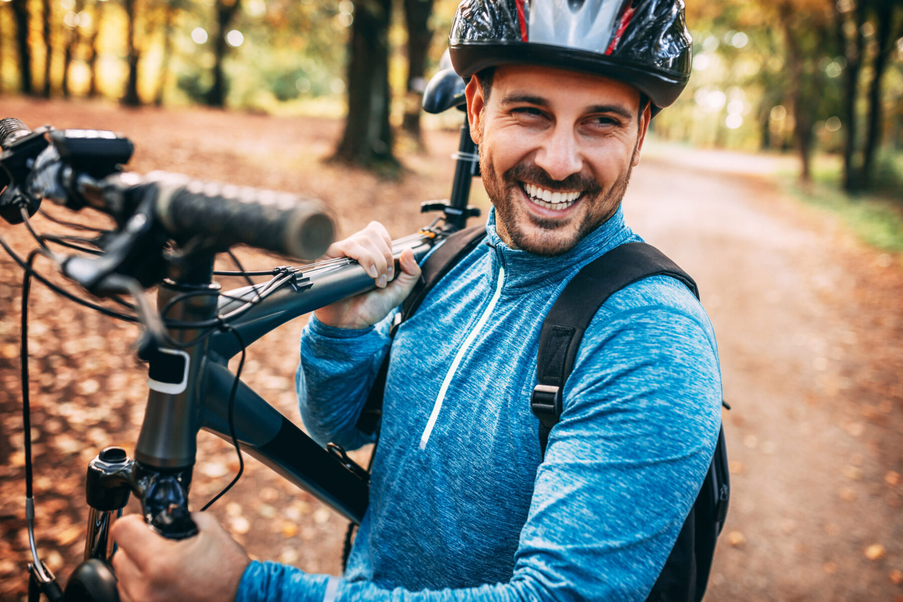 Man carrying a bike up a hiking trail