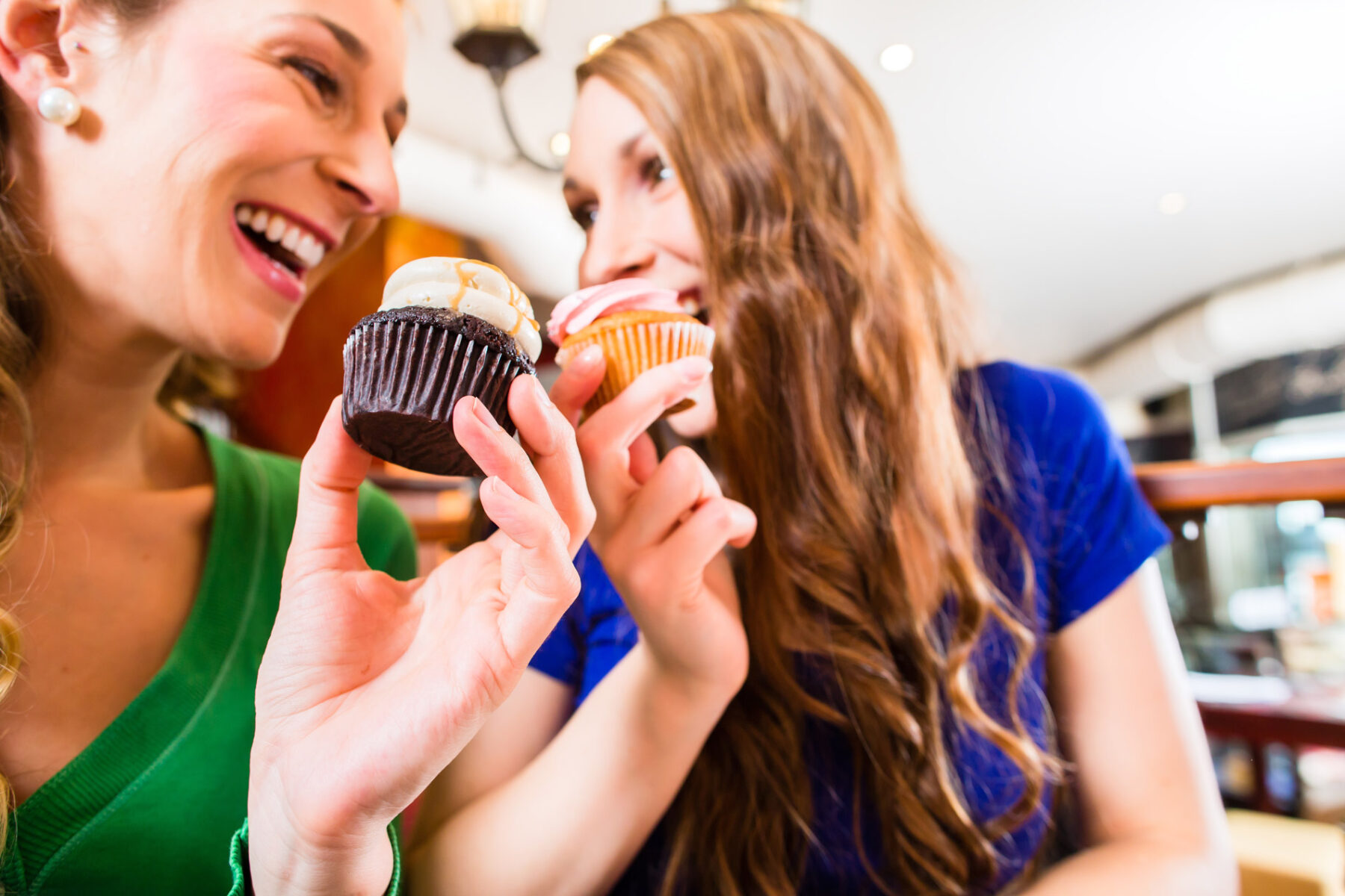 friends in a shop eating cupcakes