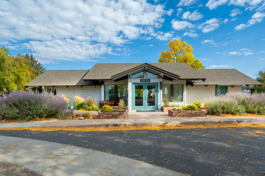 Exterior of leasing office with lots of colorful flowers